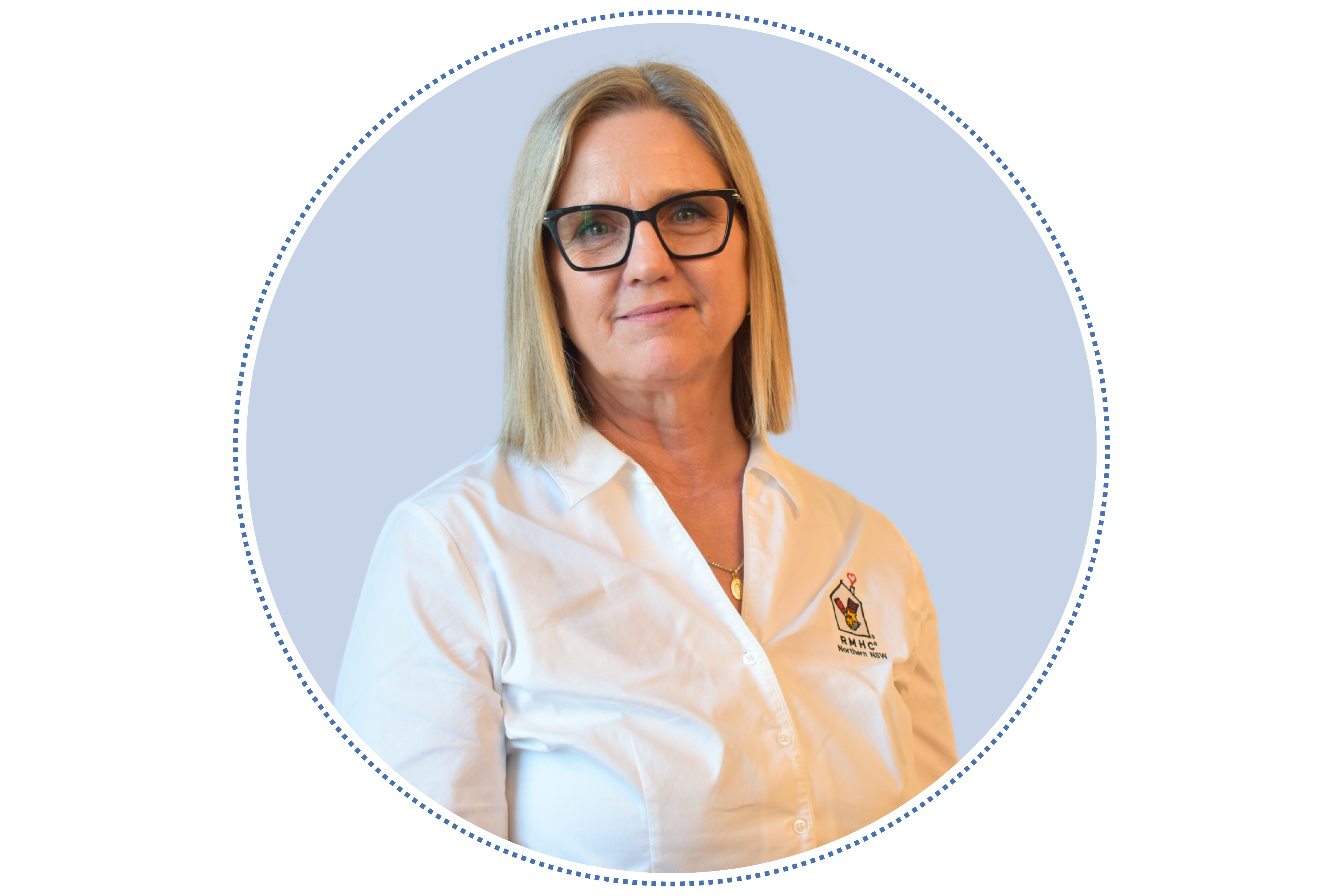 Claudia, a white woman, with blonde hair, wearing block glasses and white shirt, smiling at the camera